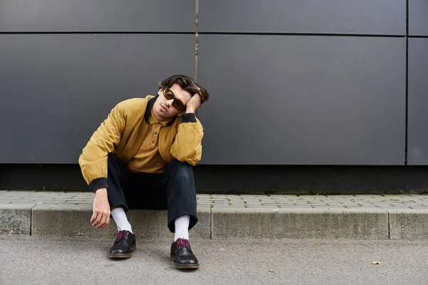 A stylish young man enjoys a moment of reflection while sporting a fashionable autumn ensemble. — Stock Photo
