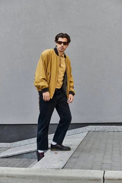 A stylish young man poses in a trendy autumn outfit, blending urban flair with seasonal charm. — Stock Photo