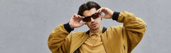 A young man showcases his fashionable autumn style while striking a confident pose outdoors. — Stock Photo