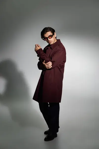 A stylish young man poses confidently in a fashionable autumn outfit, radiating charm and elegance. — Stock Photo