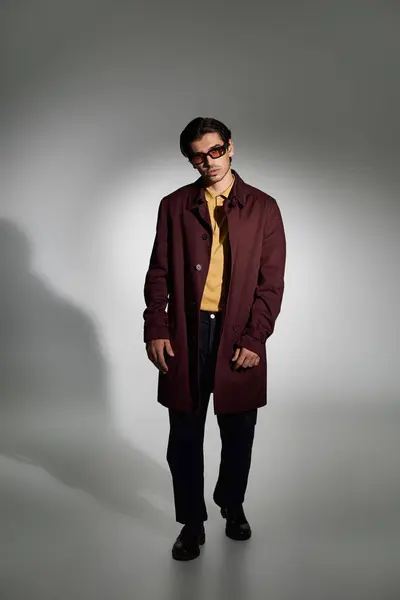 A young man displays his fashion sense in a stylish autumn outfit, exuding confidence and charisma. — Stock Photo