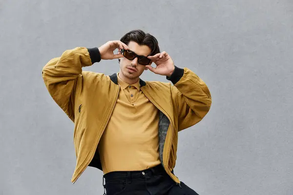 A young man confidently poses in a fashionable autumn outfit, radiating style and personality. — Stock Photo