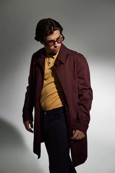 A young man showcases his fashion sense in a fashionable autumn ensemble, radiating confidence and style. — Stock Photo