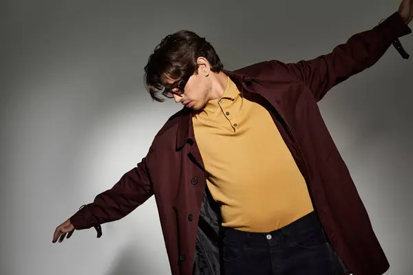 Youthful man in a stylish autumn outfit strikes a confident pose, highlighting his fashion sense and attitude. — Stock Photo