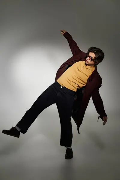 A young man strikes a playful pose, highlighting a fashionable autumn ensemble with confidence and flair. — Stock Photo