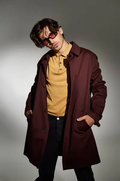 A young handsome man confidently displays his trendy autumn outfit, showcasing his unique style effortlessly. — Stock Photo