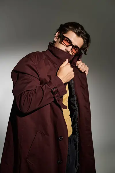 A young man showcases his trendy autumn outfit, exuding style and confidence with a striking pose. — Stock Photo