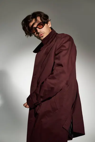 A young man showcases his fashionable autumn style with a bold and trendy outfit in a chic setting. — Stock Photo