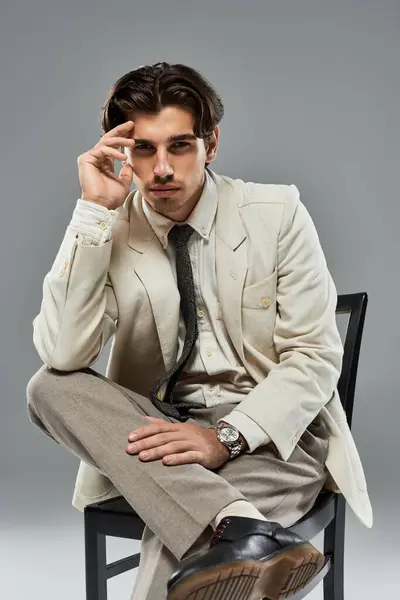 A dapper young man dressed in elegant formal wear poses confidently against a sleek grey backdrop. — Stock Photo