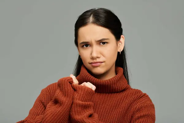 A young woman with a thoughtful expression captures attention in her fashionable sweater. — Stock Photo