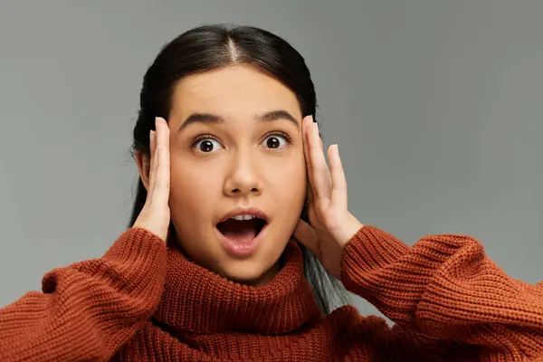 Une jeune femme émotionnelle réagit avec surprise, mettant en valeur sa tenue élégante dans un cadre apaisant. — Stock Photo