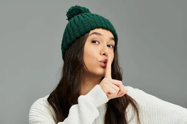 A young woman expresses her emotions while playfully gesturing for silence indoors. — Stock Photo