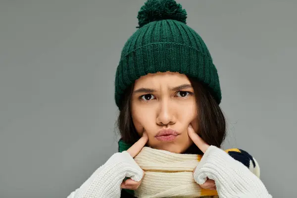 A young woman in winter clothing showcases her emotions with a playful pout and stylish accessories. — Stock Photo