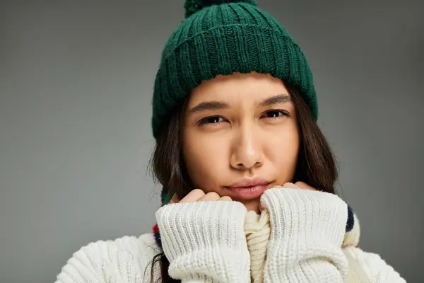 Una joven mujer expresa sus emociones mientras se viste calurosamente, capturando un momento de corazón. - foto de stock
