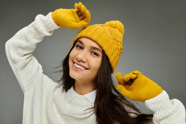 Eine junge Frau strahlt in einem kuscheligen Pullover und knallgelben Accessoires, während sie posiert. — Stockfoto