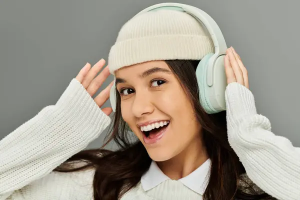 A young woman with a bright smile listens to music, embracing her fashionable style and emotion. — Stock Photo