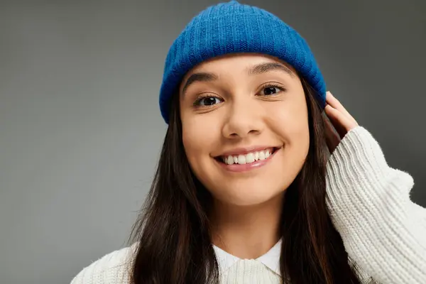 In un ambiente accogliente, una giovane donna con un berretto blu trasuda gioia e stile. — Stock Photo