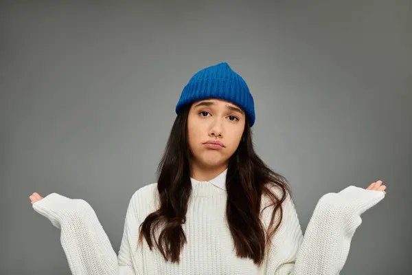 A young, pretty woman showcases her fashionable outfit while conveying deep emotions. — Stock Photo