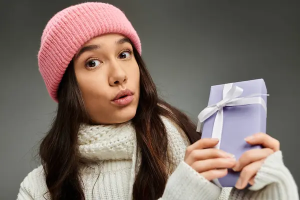 Excitement fills the air as a young woman models her trendy look with a thoughtful gift in hand. — Stock Photo
