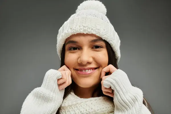 A young woman smiles brightly while wearing a cozy white winter outfit. — Stock Photo