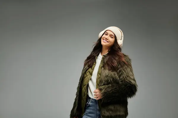 A young woman expresses her emotions while showcasing trendy winter attire, radiating happiness. — Stock Photo