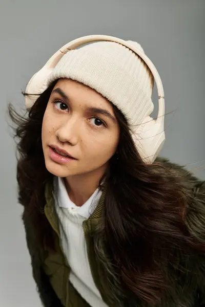 A young woman showcases her emotions while donning a trendy outfit and oversized headphones. — Stock Photo