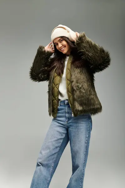 A young woman in trendy winter clothing radiates joy while posing with a charming flair. — Stock Photo