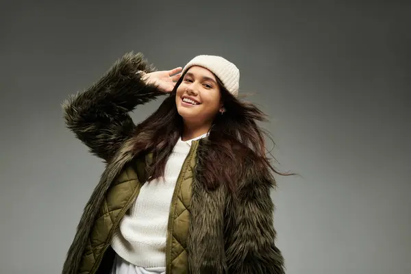 A young woman with an expressive smile enjoys the moment, showcasing her trendy winter attire. — Stock Photo