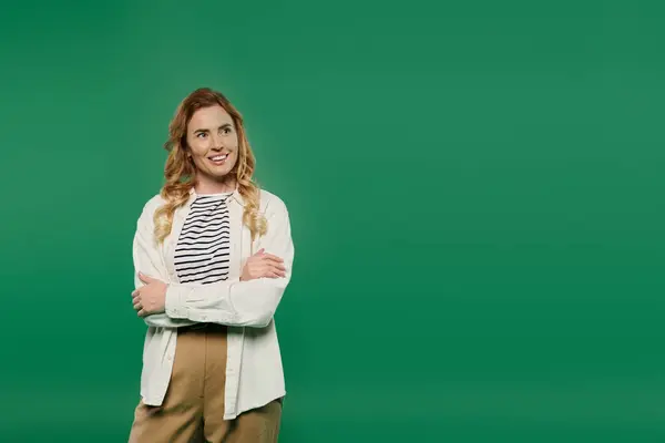 A stylish woman with curly hair stands casually, wearing a striped top, exuding confidence and charm. — Stock Photo