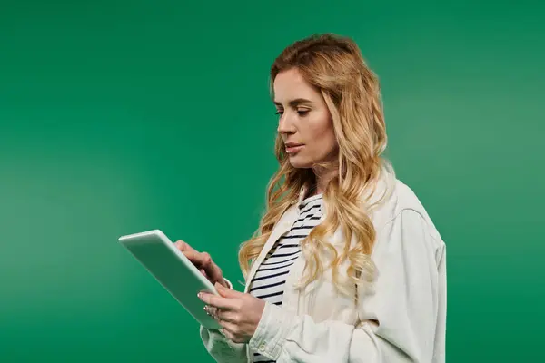 A stylish woman with curls engages with a tablet, radiating confidence in a chic setting. — Stock Photo