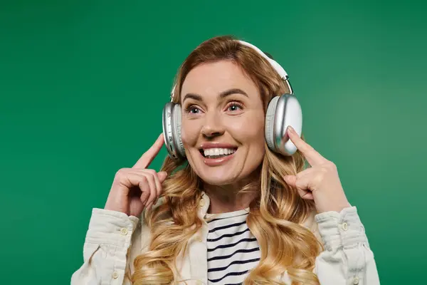 These carefree moments capture a woman with curly hair, smiling brightly while listening to music. — Fotografia de Stock