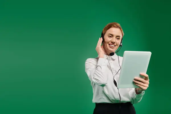 A professionally dressed woman interacts with clients using a tablet, radiating positivity and professionalism. — Stock Photo