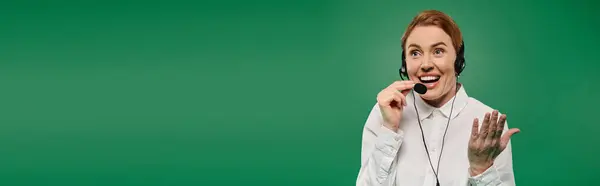 A professional woman in a white shirt communicates enthusiastically with clients using a headset. — Stock Photo