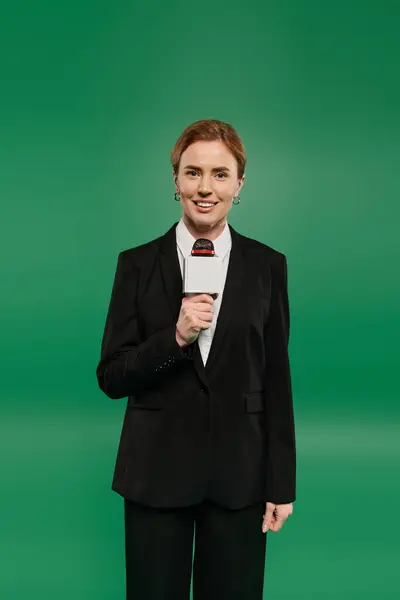 The TV presenter holds a microphone and smiles warmly, ready to engage with the audience — Stock Photo