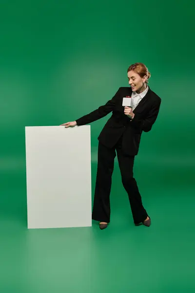 A stylish presenter holds a microphone, ready to engage viewers — Stock Photo
