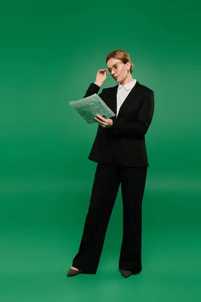 A poised presenter wearing a black suit engages with a news, ready to captivate viewers in a studio. — Stock Photo