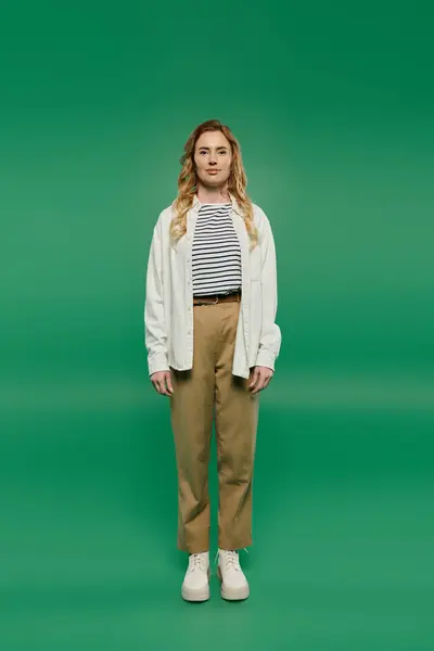 A woman in casual clothing poses with poise, showcasing her style against a bright green backdrop. — Stock Photo
