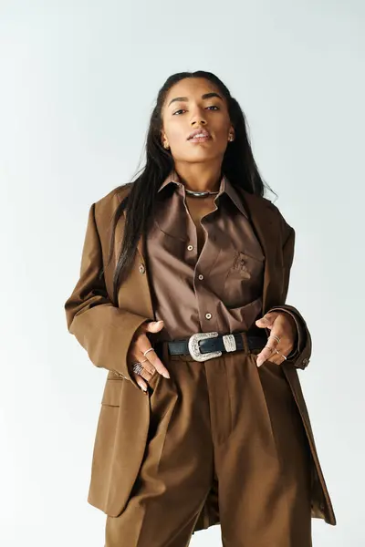 Dressed in a trendy brown outfit, a young woman poses elegantly with confidence and flair. — Stock Photo