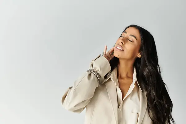 A young woman in fashionable attire elegantly poses, exuding confidence and style. — Stock Photo