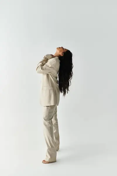 A stylishly dressed young woman showcases elegance and confidence in a modern outfit. — Stock Photo