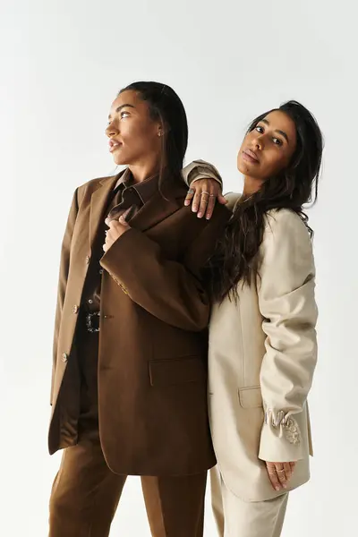 Two young women in trendy attire exude confidence while striking stylish poses together. — Stock Photo
