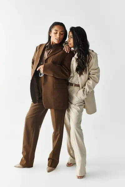Two young women dressed in elegant outfits pose confidently, displaying their unique fashion sense. — Stock Photo