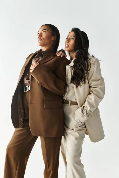 Two young women dressed in fashionable outfits exude confidence and style while posing gracefully. — Stock Photo