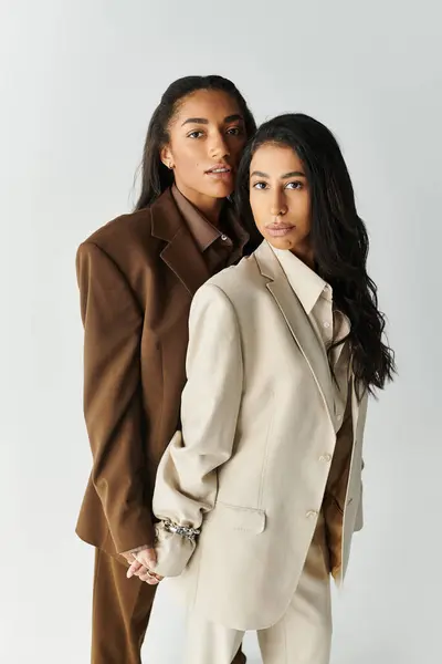 Two young women in elegant suits, showcasing their stylish attire and confident demeanor together. — Stock Photo