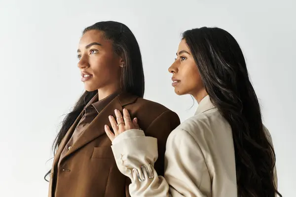 Zwei junge Frauen strahlen Vertrauen in trendige Kleidung aus, die einen schicken urbanen Lebensstil widerspiegelt. — Stockfoto