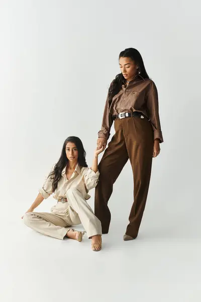 Two fashionable young women express confidence in elegant attire, highlighting their unique styles. — Stock Photo