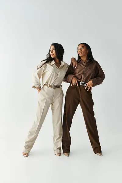 Two fashionable young women showcase trendy outfits with confidence and poise. — Stock Photo