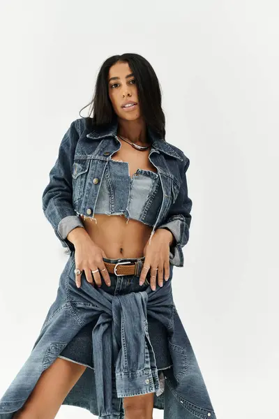 Une jeune femme fait preuve de confiance et de style dans son ensemble chic en denim, rayonnant de joie. — Photo de stock