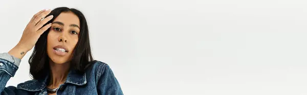 A cheerful young woman showcases her trendy denim outfit, exuding joy and style. — Stock Photo