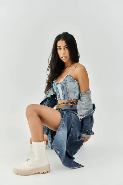 The young woman showcases trendy denim fashion while striking a playful pose, exuding confidence. — Stock Photo